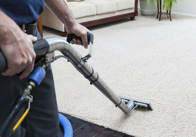 Man cleaning carpets in home